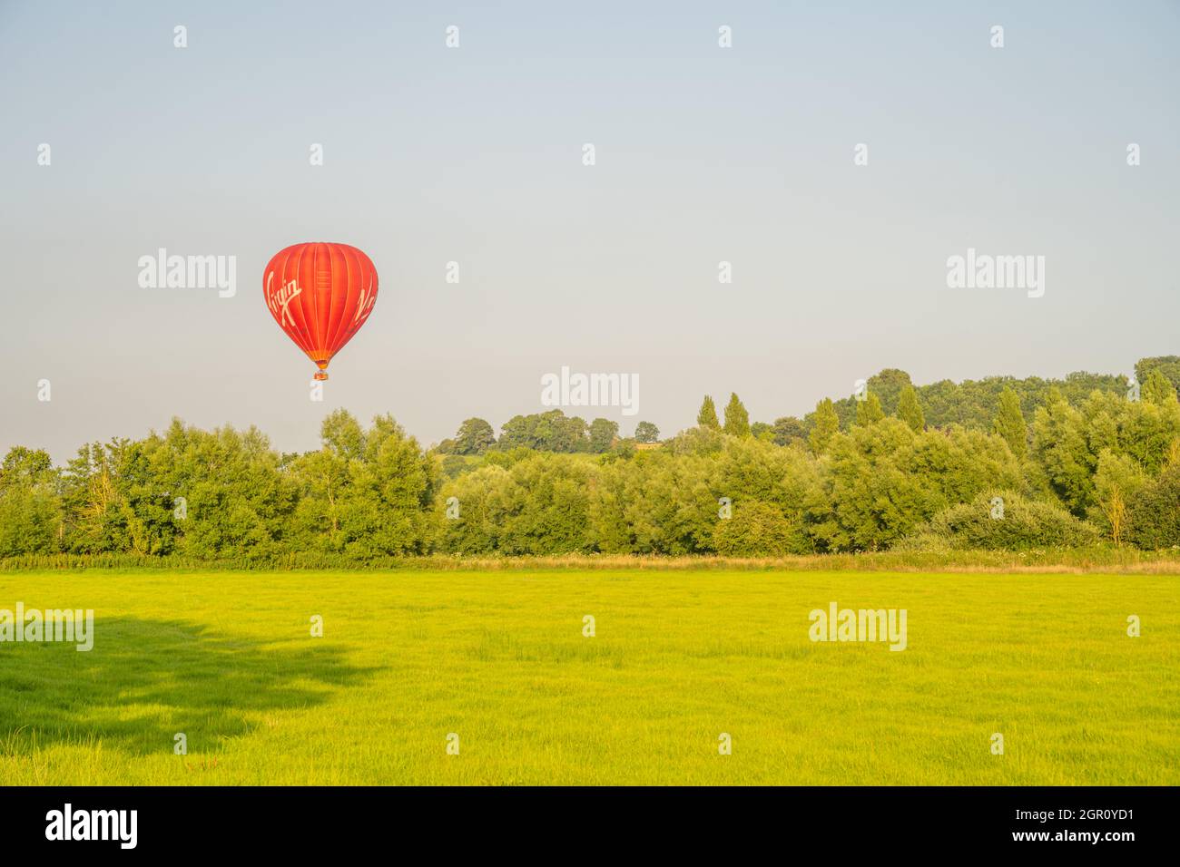 Le ballon d'air chaud vierge qui monte d'un champ près de Glastonbury Somerset. Près du coucher du soleil Banque D'Images