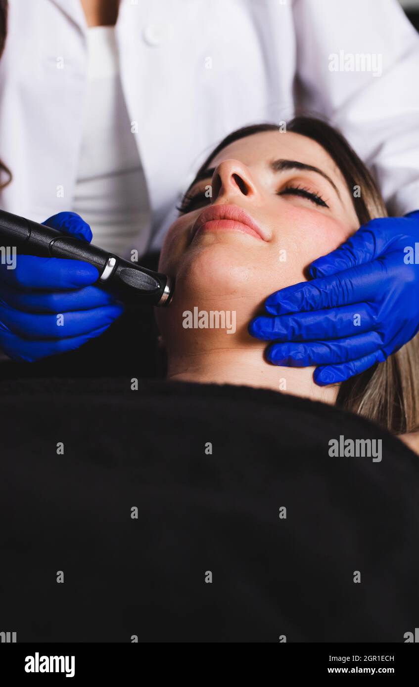 Une jeune femme nettoyant son visage dans une clinique esthétique Banque D'Images