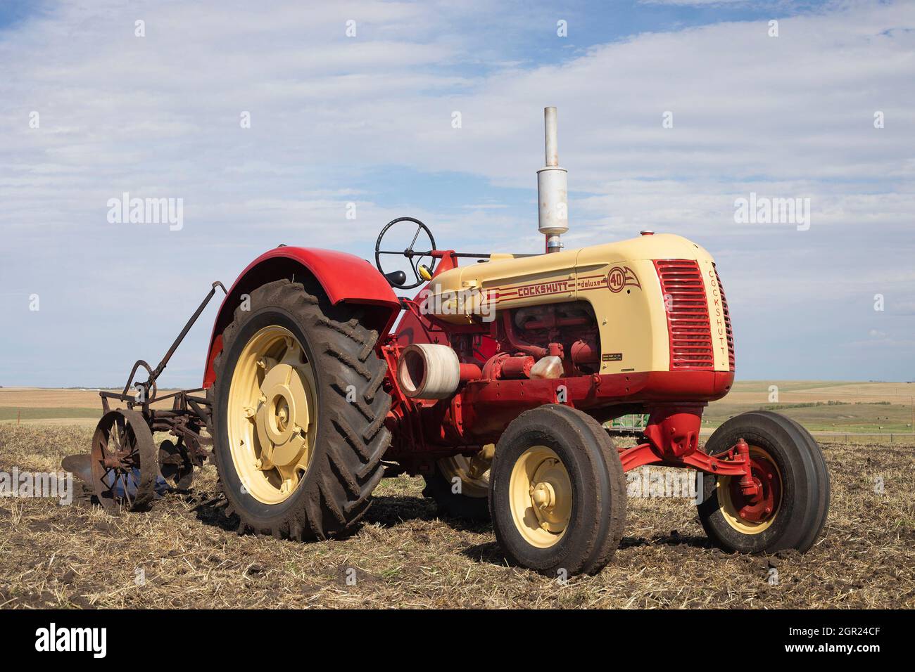 Cockshutt modèle 40 Deluxe tracteur d'époque tirant une charrue dans un champ de ferme pour labourer le sol après la récolte. Ce modèle a été fabriqué de 1949 à 1958 Banque D'Images
