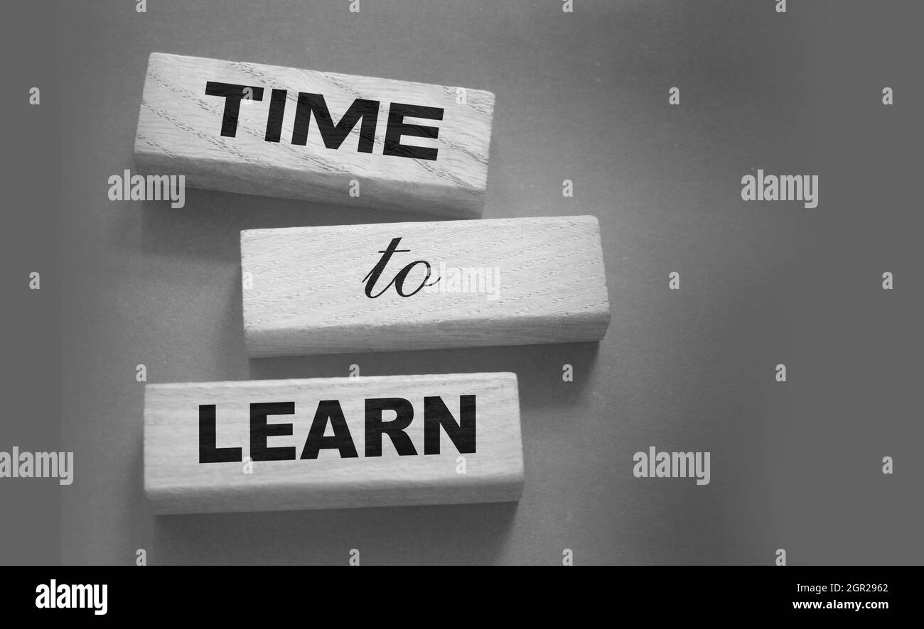 Le temps d'apprendre sur les blocs de bois mis noir. Concept d'éducation. Concept d'entreprise d'apprentissage en temps de vie Banque D'Images
