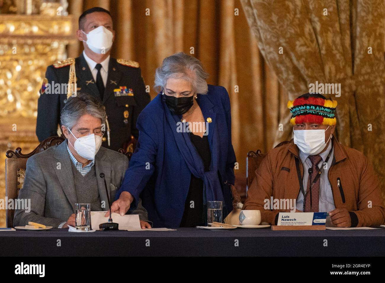 Un conseiller du président équatorien Guillermo Lasso place un papier devant lui tout en écoutant les remarques d'ouverture de Luis Nawech (à gauche), président d'une organisation autochtone de la nation Shuar.le président équatorien Guillermo Lasso a accueilli les dirigeants de la communauté autochtone de Shuar au palais présidentiel de la capitale du pays, Quito. Les deux parties ont tenu une réunion axée sur les préoccupations en matière de santé, d'éducation et d'environnement. Les dirigeants de Shuar ont également mentionné la création d'un nouveau comté dans la province de Morona Santiago, en Amazonie équatorienne. Banque D'Images