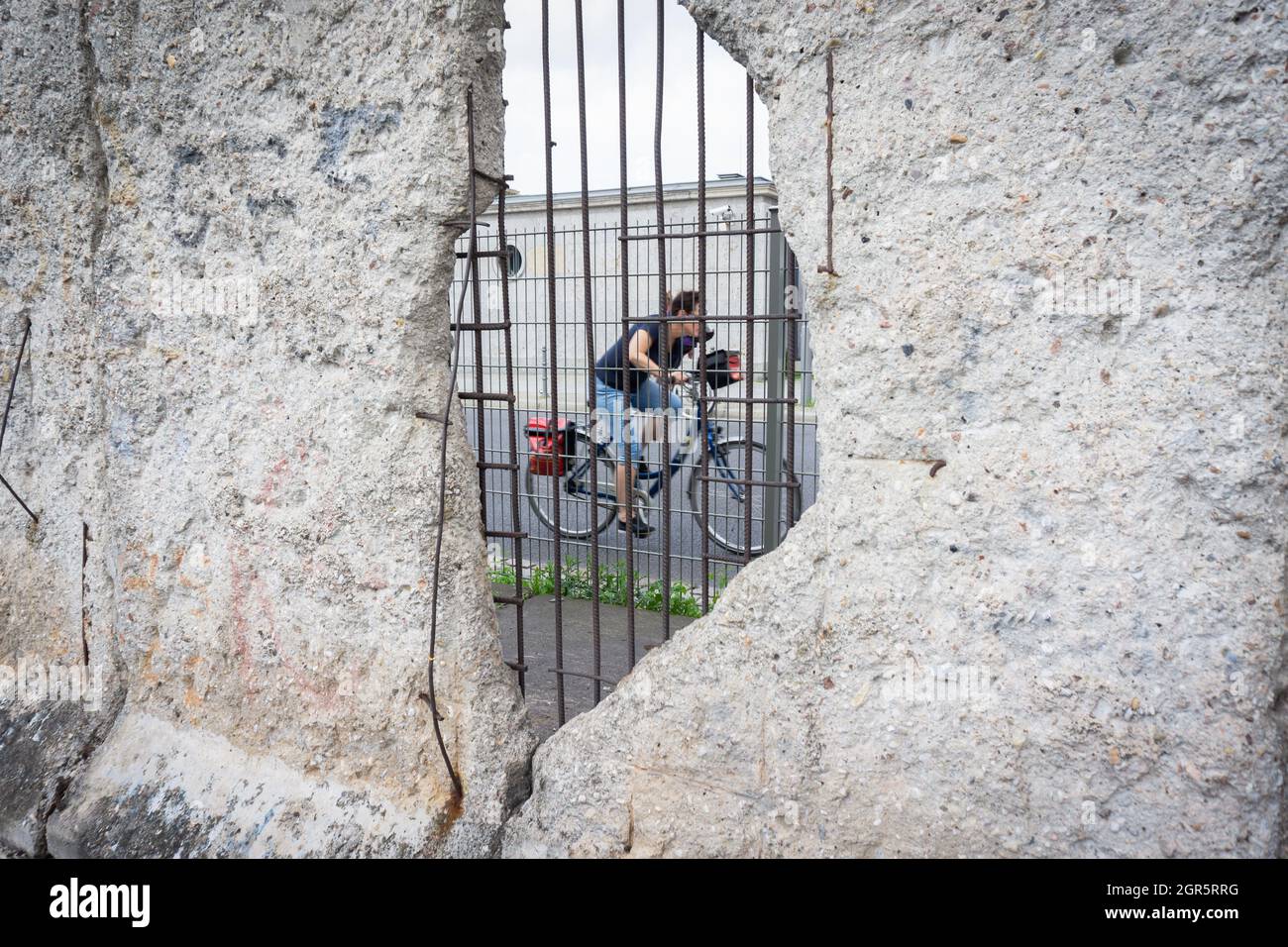 Berlin, Allemagne - 25 septembre 2017: Scène à travers Berlin trou du mur brisé avec renforcement de fer vue sur la rue comme la femme floue dans le mouvement de la promenade Banque D'Images