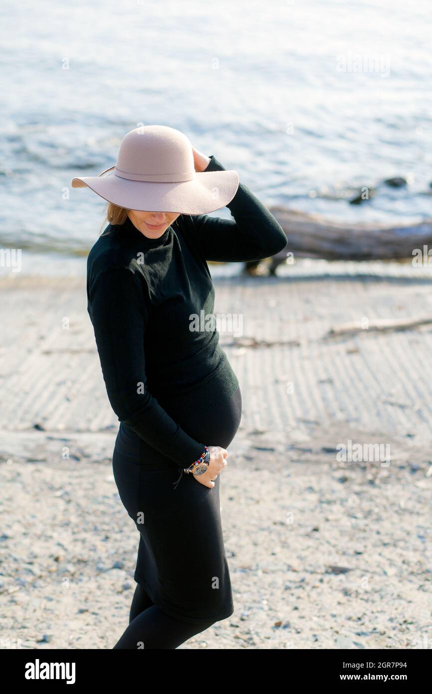 Portrait d'Une jeune femme enceinte dans Un col roulé noir et une jupe  mouchete noire Photo Stock - Alamy