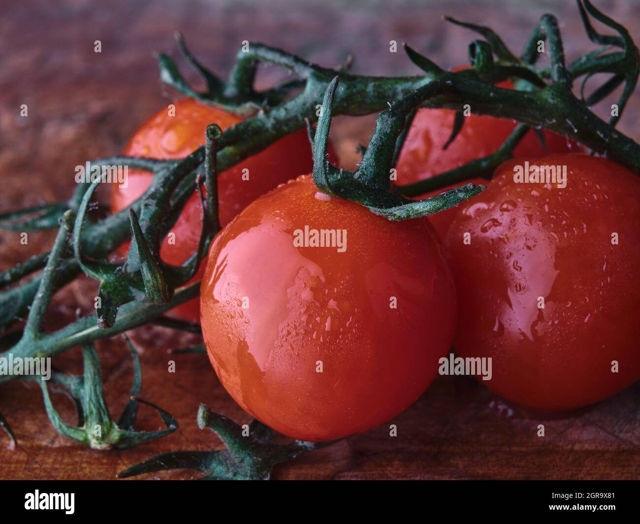 Tomates mûres sur fond sombre de table en bois Banque D'Images