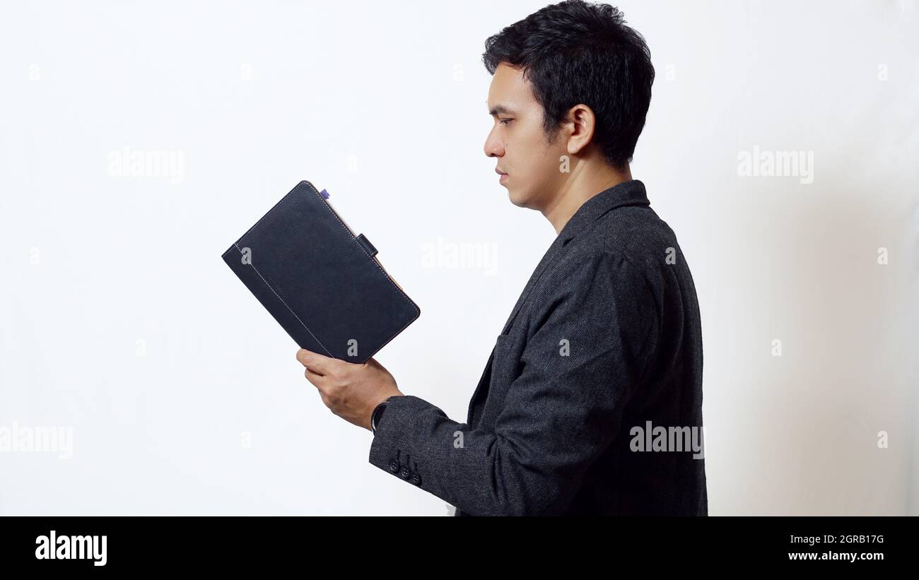 Livre de lecture asiatique sur fond blanc Banque D'Images