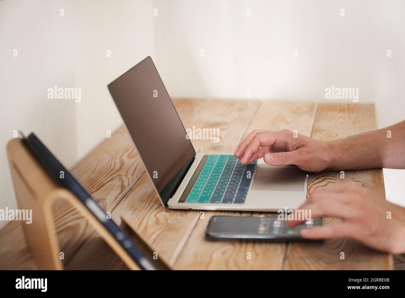 Gros plan des mains d'un homme tapant sur un clavier, à la recherche d'informations. Un rédacteur pigiste travaille sur un projet. Le concept de travail à distance. Photo de haute qualité Banque D'Images