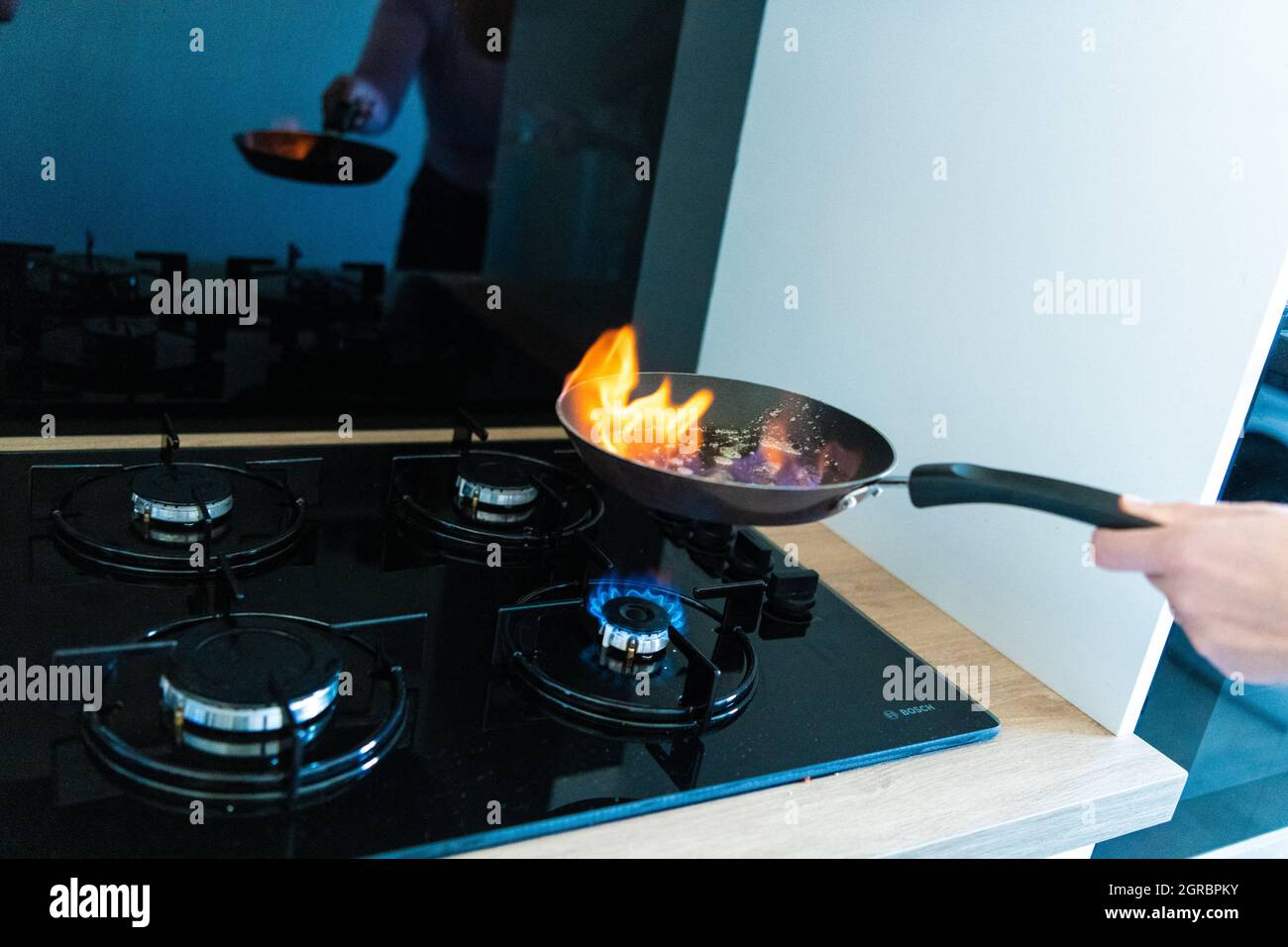 Une femme fait un flambeau dans une poêle sur une flamme sur la cuisinière  à gaz dans une cuisine. Clamart, France, 30 septembre 2021. Hausse du prix  de l'essence. Le 1er octobre