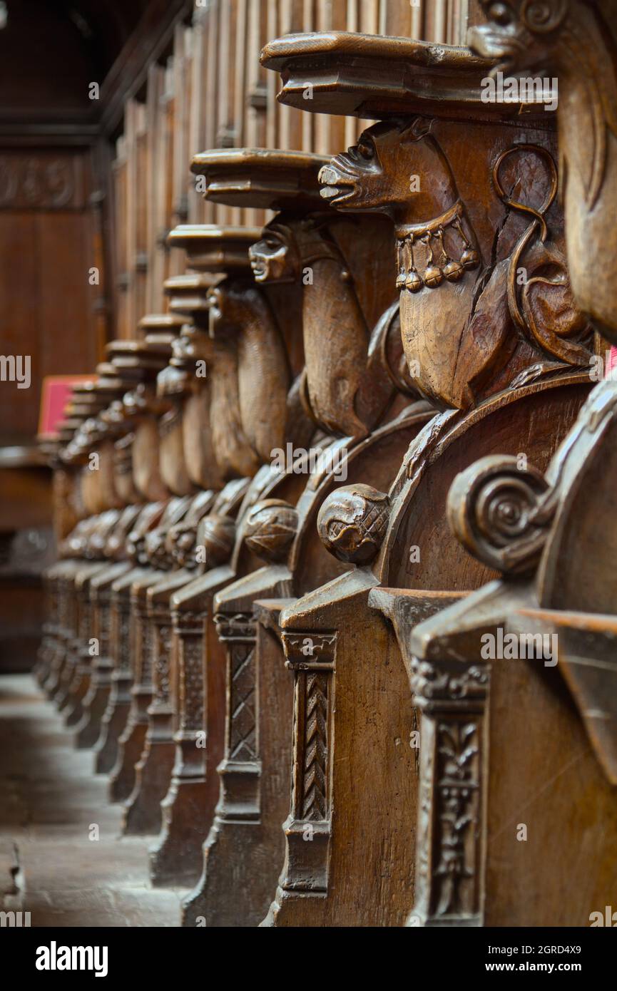 Rangée de sièges de Monks en bois sculpté, Mercy sièges partie des Misericords dans le Grand Quire, Prieuré de Christchurch, Royaume-Uni Banque D'Images
