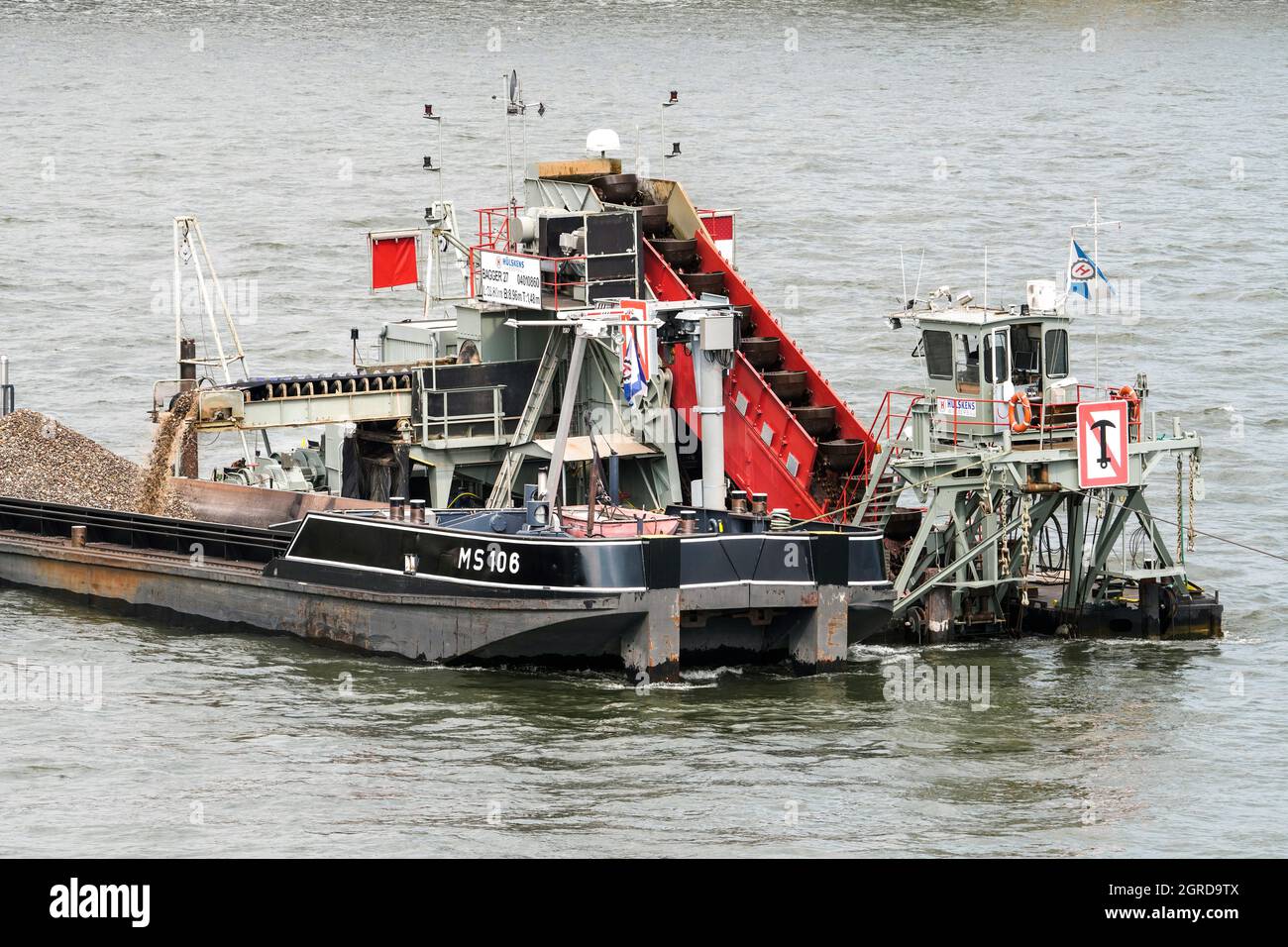 Un dredger de la société Hülskens Wasserbau approfondit et élargit le canal de navigation dans le Rhin près de Cologne. --- Baggerschiff der Firma Hülskens Hydrotechnik vertieft und verbreitert im Rhein in Köln die Fahrrinne für die Schiffahrt. Banque D'Images
