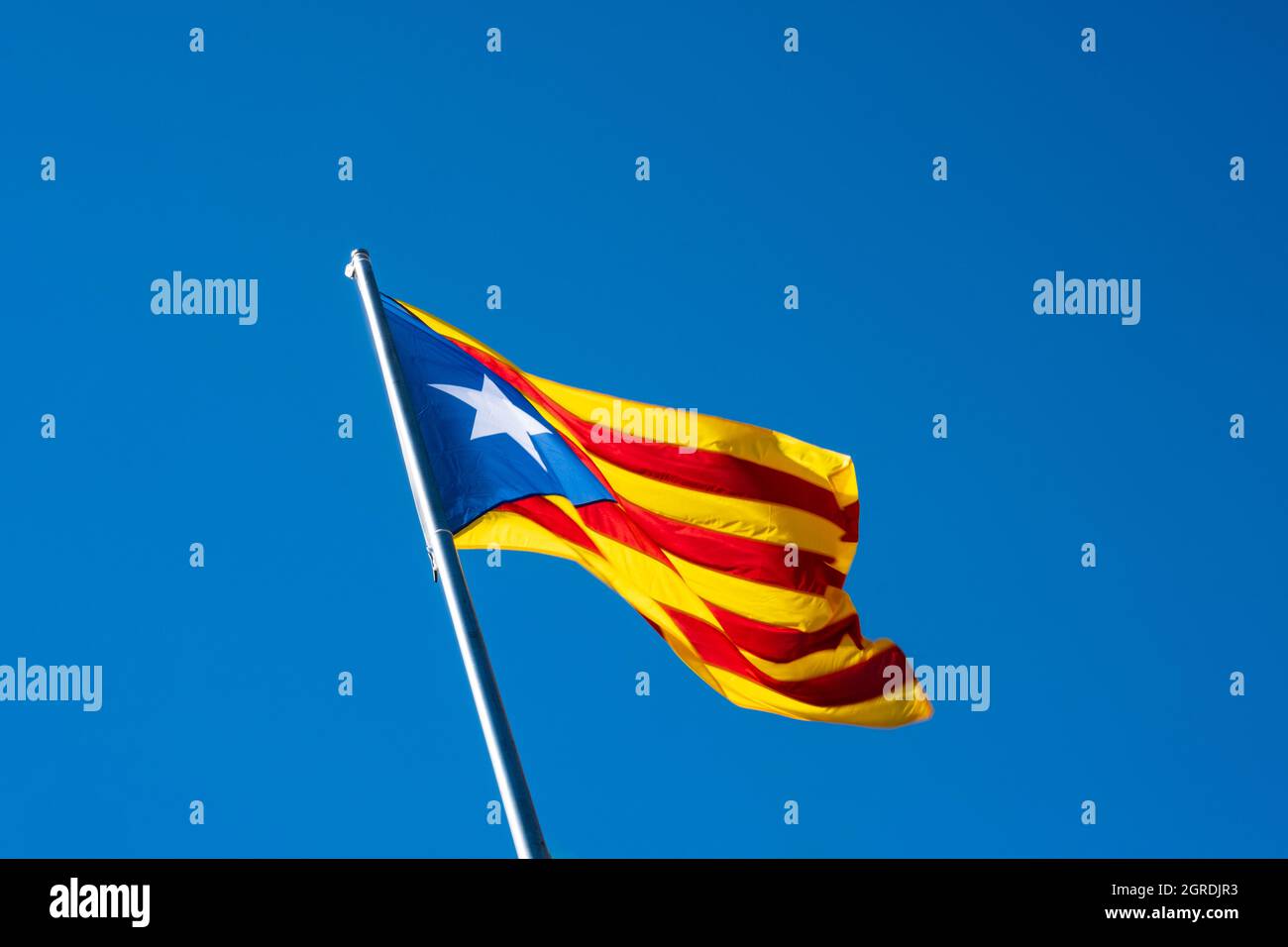 Le drapeau Sényera ESTELADA, quatre bandes rouges sur un champ jaune et un triangle bleu avec une étoile sur le côté gauche, symbole de la revendication de l'indépendance de Banque D'Images