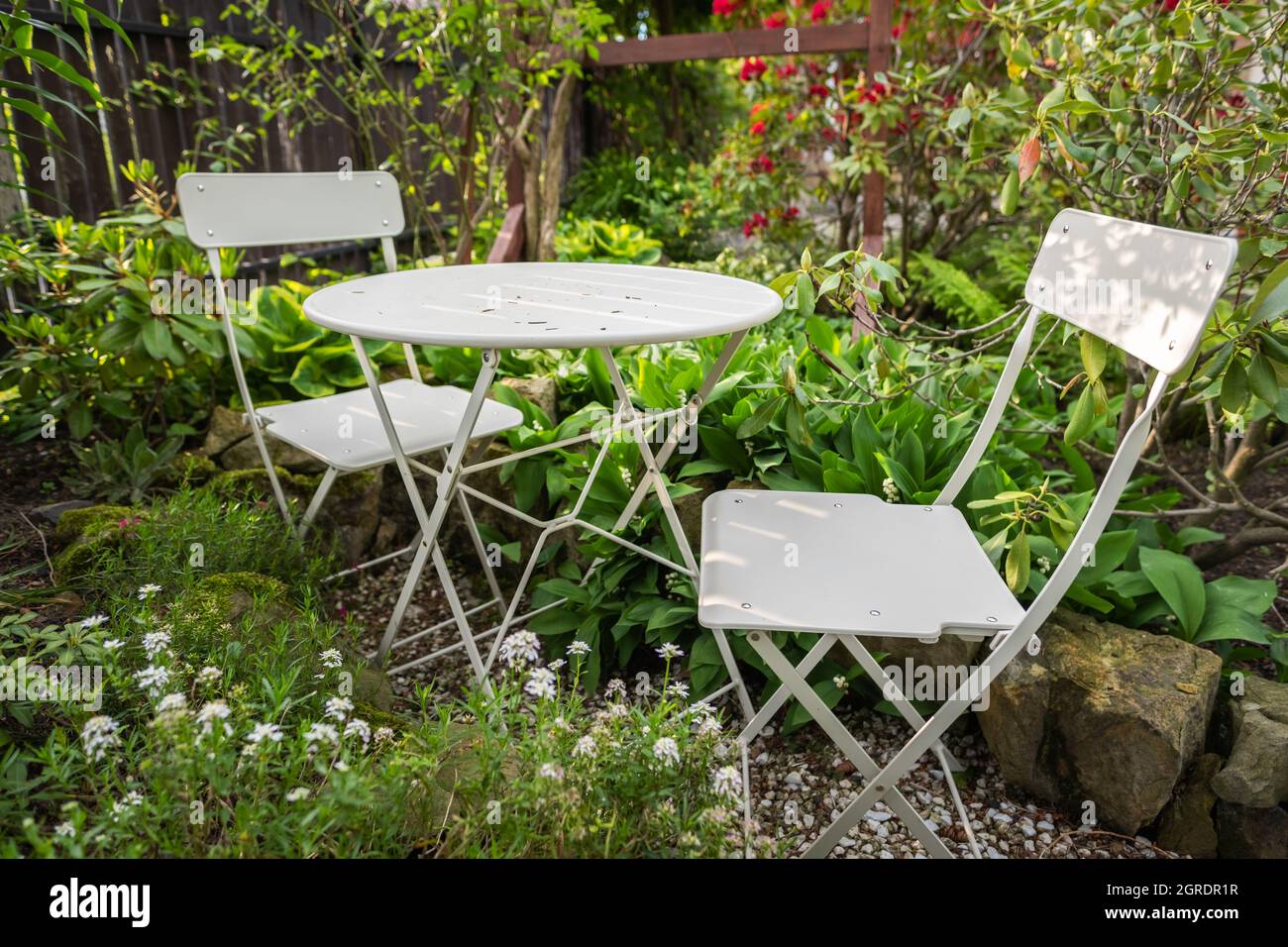 Table basse de bistro vide avec chaises dans le jardin vert Banque D'Images