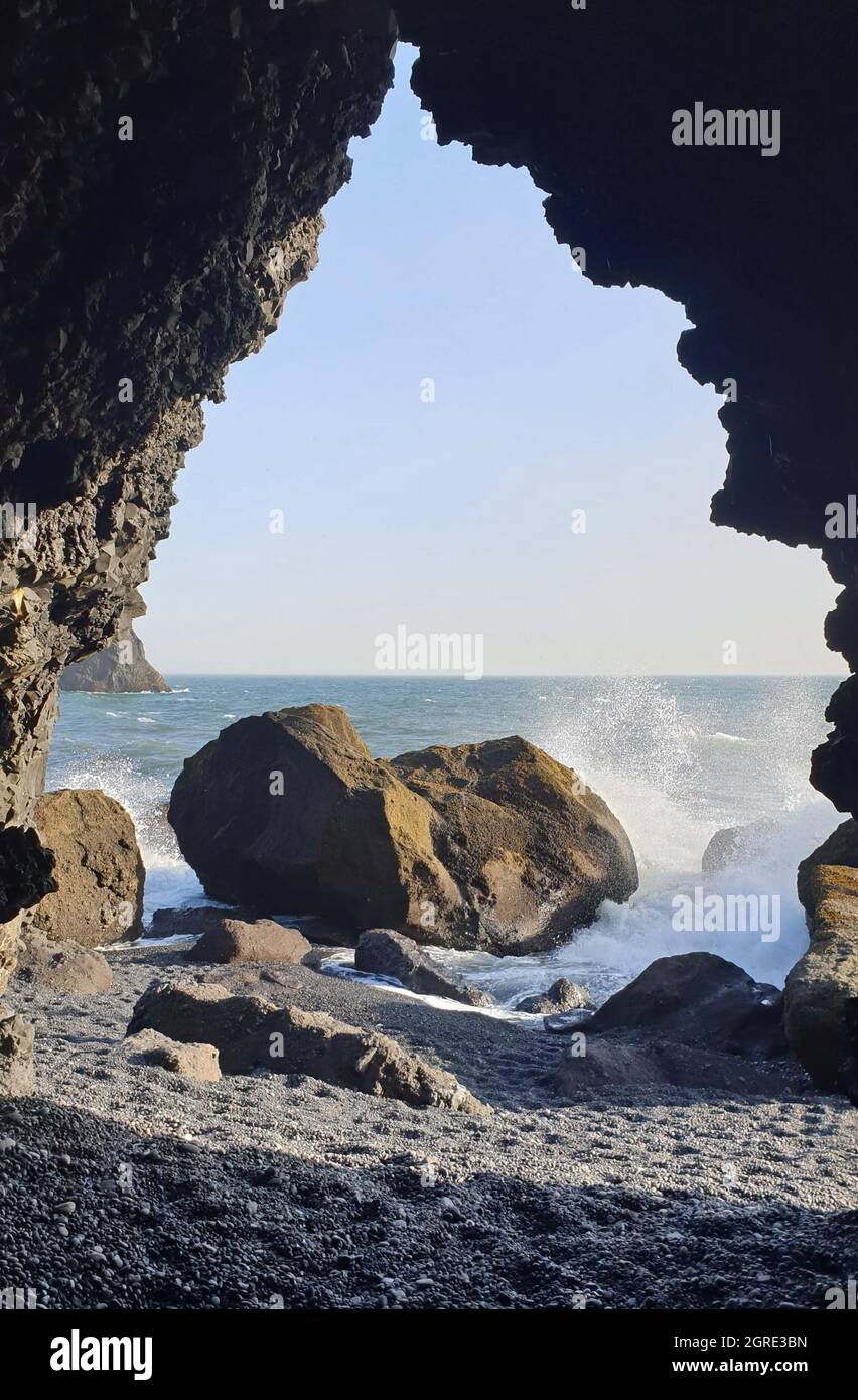 Vagues arrivant à Reynisfjara Black Beach, Islande, avec des formations rocheuses en arrière-plan Banque D'Images