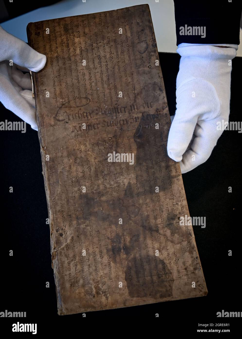 Leipzig, Allemagne. 1er octobre 2021 : Michael Ruprecht, directeur des archives, présente un manuscrit du IXe siècle dans les archives de la ville de Leipzig. La découverte sensationnelle reste dormante dans les fonds propres de l'archive. Le manuscrit a formé la chemise de poussière d'un livre mortuaire municipal datant d'environ 1640. Le fragment a été examiné par des scientifiques. Il appartient à un manuscrit qui a été écrit au deuxième quart du neuvième siècle dans l'abbaye impériale de Fulda. Il a été découvert que d'autres fragments du même manuscrit ont été conservés dans la bibliothèque de l'université, où ils ont été donnés en 1927. C Banque D'Images