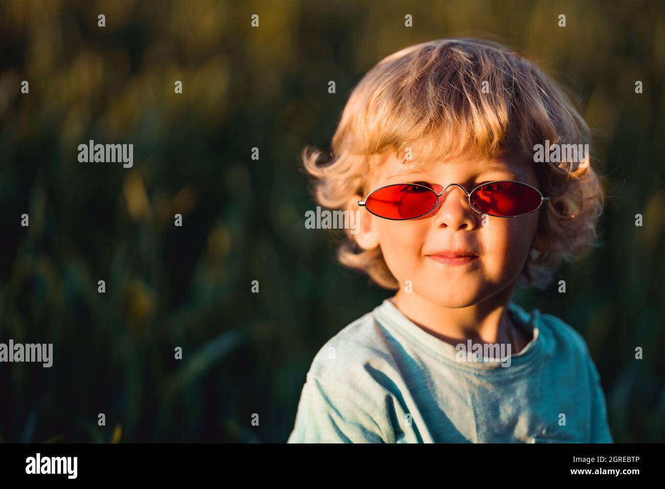 Drole De Cheveux Boucles Bebe Garcon Dans Des Lunettes De Soleil Rouges Debout Dans Le Champ De Ble Vert Frais Un Enfant Adorable Explore Les Plantes La Nature Au Printemps Enfance Photo