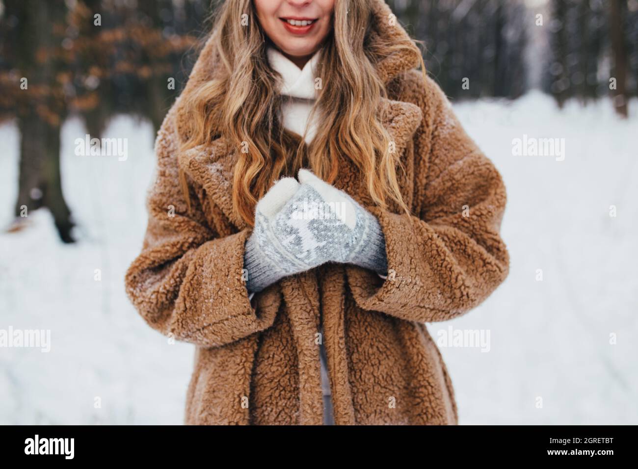 Jeune femme en manteau de fourrure, gants et écharpe dans la forêt de neige.Arrière-plan flou.Photo haute qualité Banque D'Images