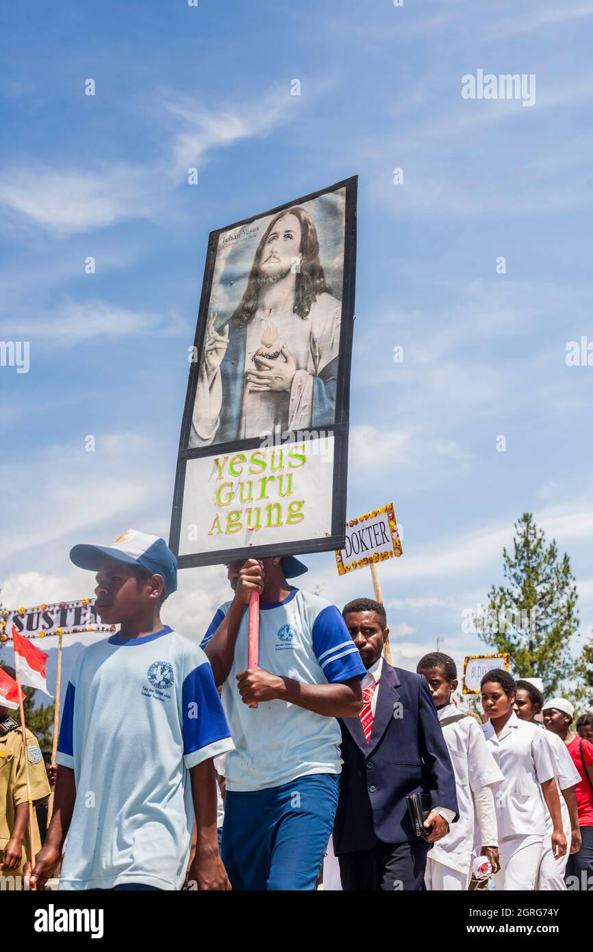 Indonésie, Papouasie, centre-ville de Wamena, célébration de la Journée de l'indépendance de l'Indonésie, défilé de Papuans impliqués dans une organisation catholique. Chaque communauté est invitée à défilé avec le drapeau indonésien, tout en présentant sa culture à travers des danses et des vêtements traditionnels, afin de renforcer le sentiment de liberté culturelle. Banque D'Images