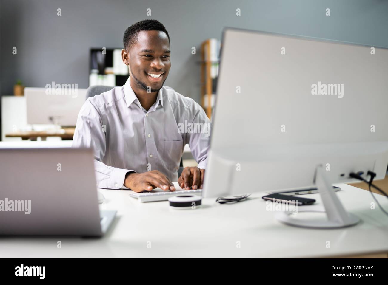 Un employé de Happy Professional Man utilisant l'ordinateur pour le travail Banque D'Images