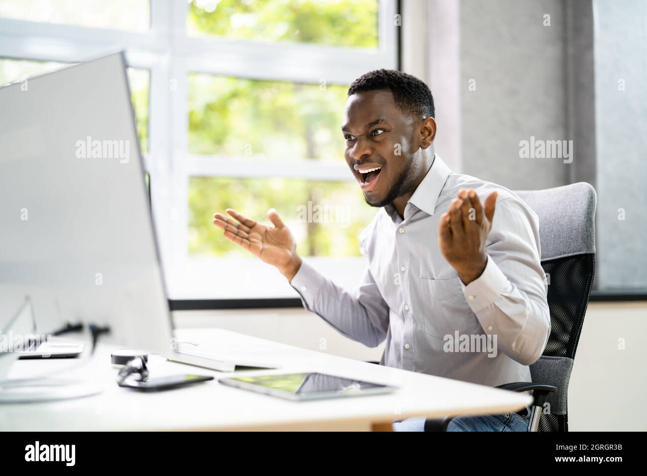 Un homme africain choqué avec Ransomware sur ordinateur de bureau Banque D'Images