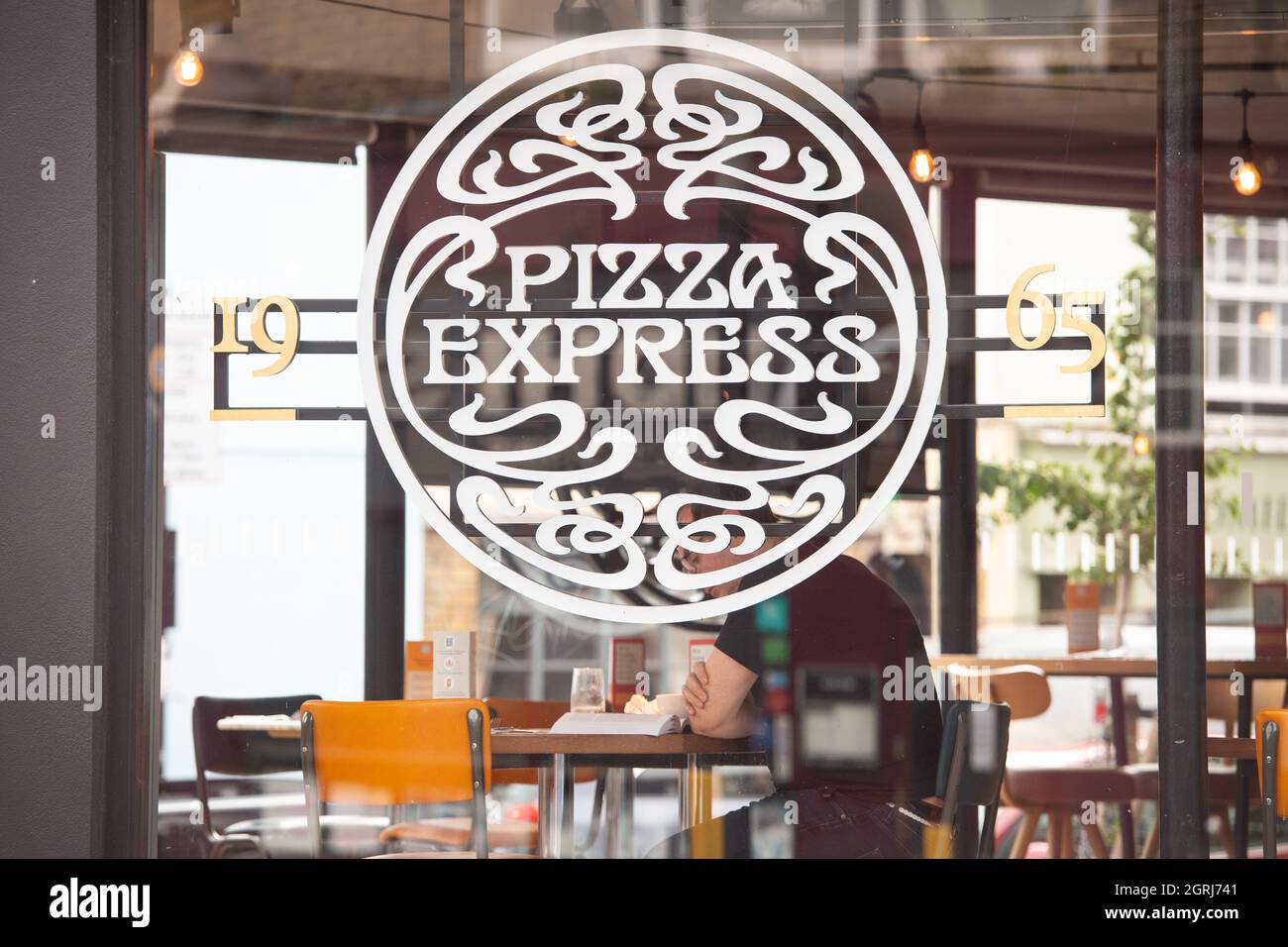 Photo du dossier datée du 04/08/20 d'Un client qui dînait dans une succursale de Pizza Express à Londres, qui a annoncé qu'il était « en bonne voie » et qu'il avait l'intention d'ouvrir 50 nouveaux restaurants alors qu'il cherche à rebondir après le bilan de la pandémie. La chaîne des restaurants, qui est entrée dans la pandémie avec un lourd fardeau de la dette, a réduit à plus de 70 2,400 le nombre de restaurants et à peu près 50 000 emplois depuis le coup de Covid dans le cadre des efforts de restructuration visant au mettre sur la voie de la durabilité. Banque D'Images