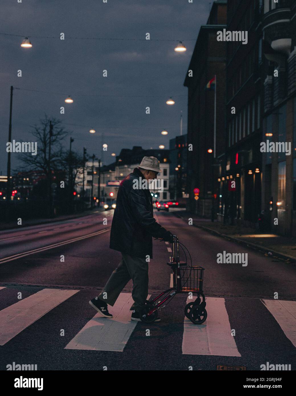 MALMO, SUÈDE - 01 septembre 2021 : un homme inconnu traversant la rue avec un marcheur avec un panier Banque D'Images