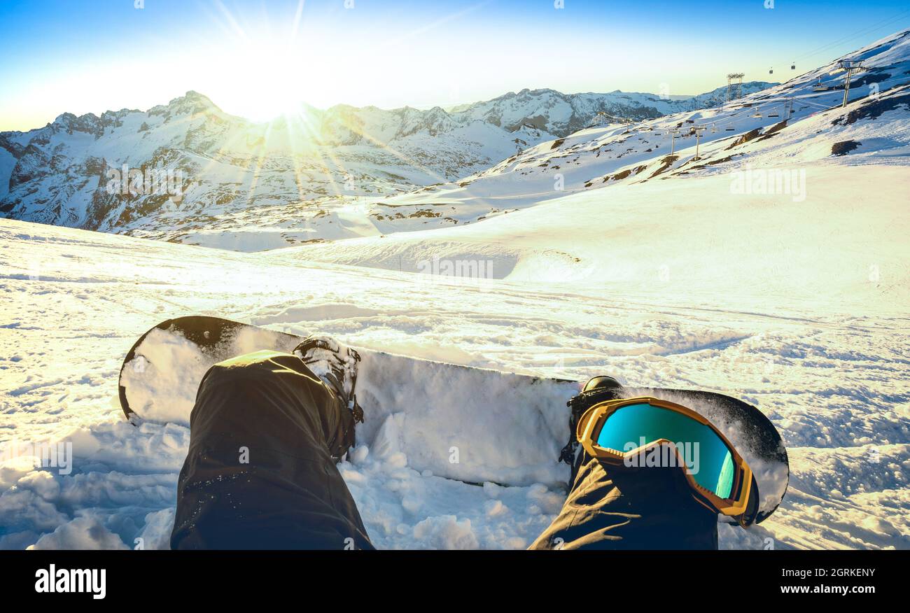 Snowboardeur assis sur un moment de détente au coucher du soleil dans la station de ski des deux Alpes - concept de sport d'hiver avec personne au sommet de la montagne prêt à monter Banque D'Images