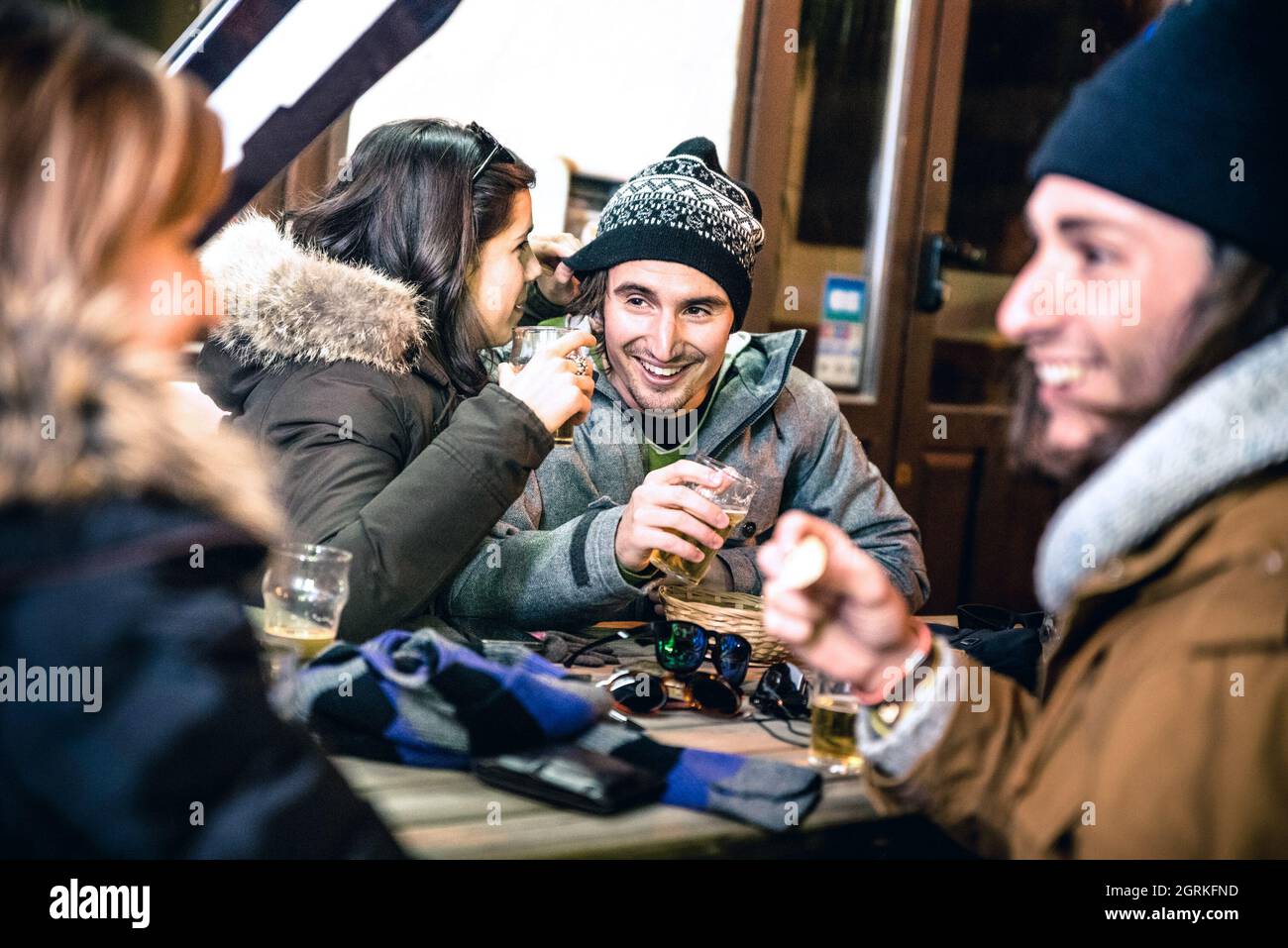 Des amis heureux buvant de la bière et mangeant des frites la nuit - concept de l'amitié avec des gens gais s'amusant au bar restaurant Resort Banque D'Images