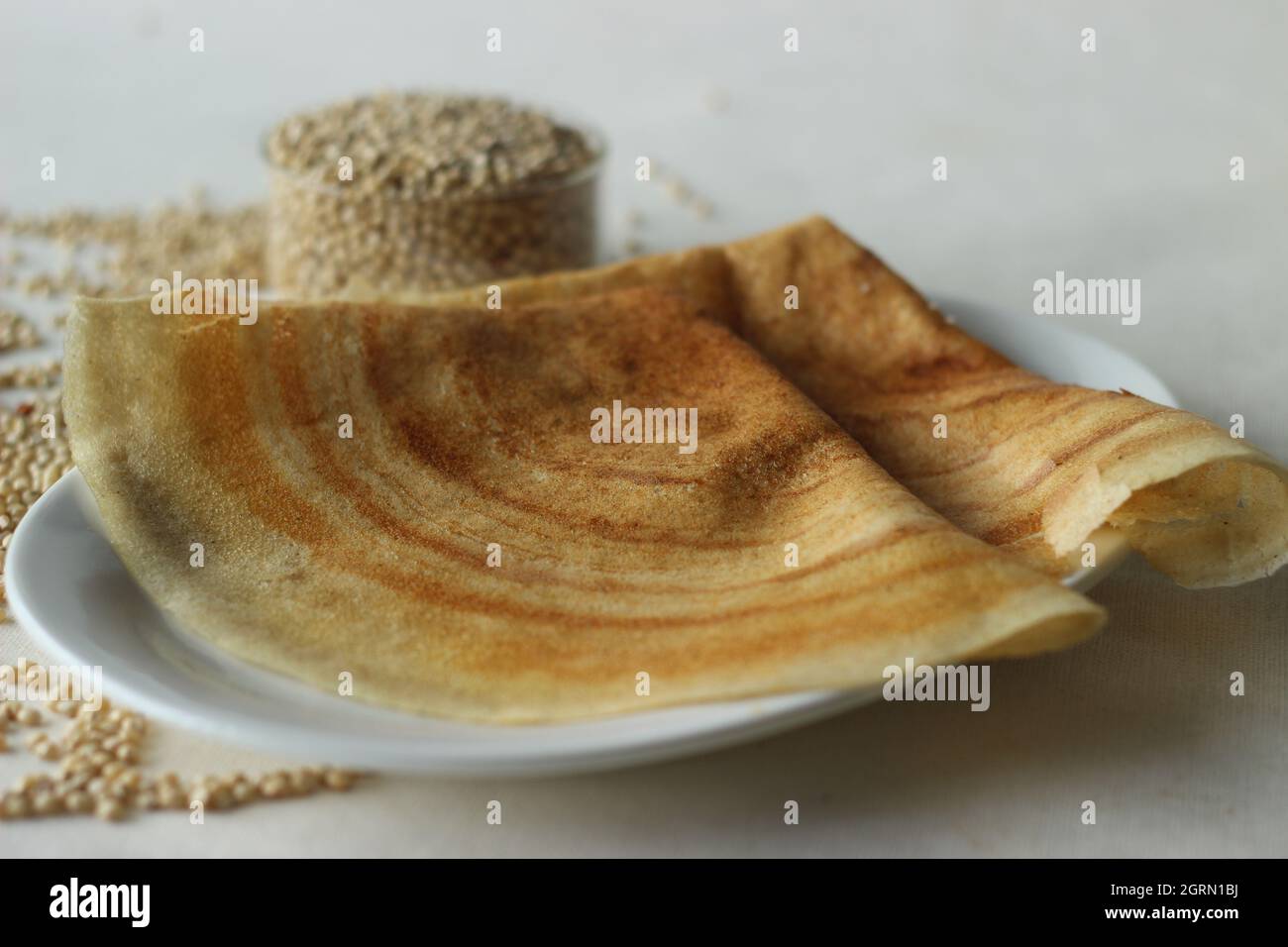 Crêpes au sorgho. Crêpes croustillantes faites de sorgho à grains entiers et de lintels. Populairement connu sous le nom de Jowar dosa. Prise de vue sur fond blanc Banque D'Images