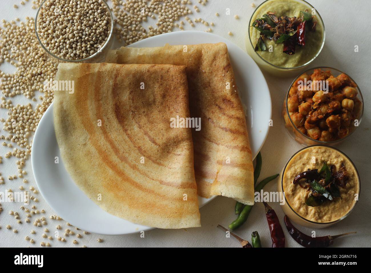 Crêpes au sorgho. Crêpes croustillantes faites de sorgho à grains entiers et de lintels. Populairement connu sous le nom de Jowar dosa. Servi avec du masala de pois chiches et des condiments. Banque D'Images