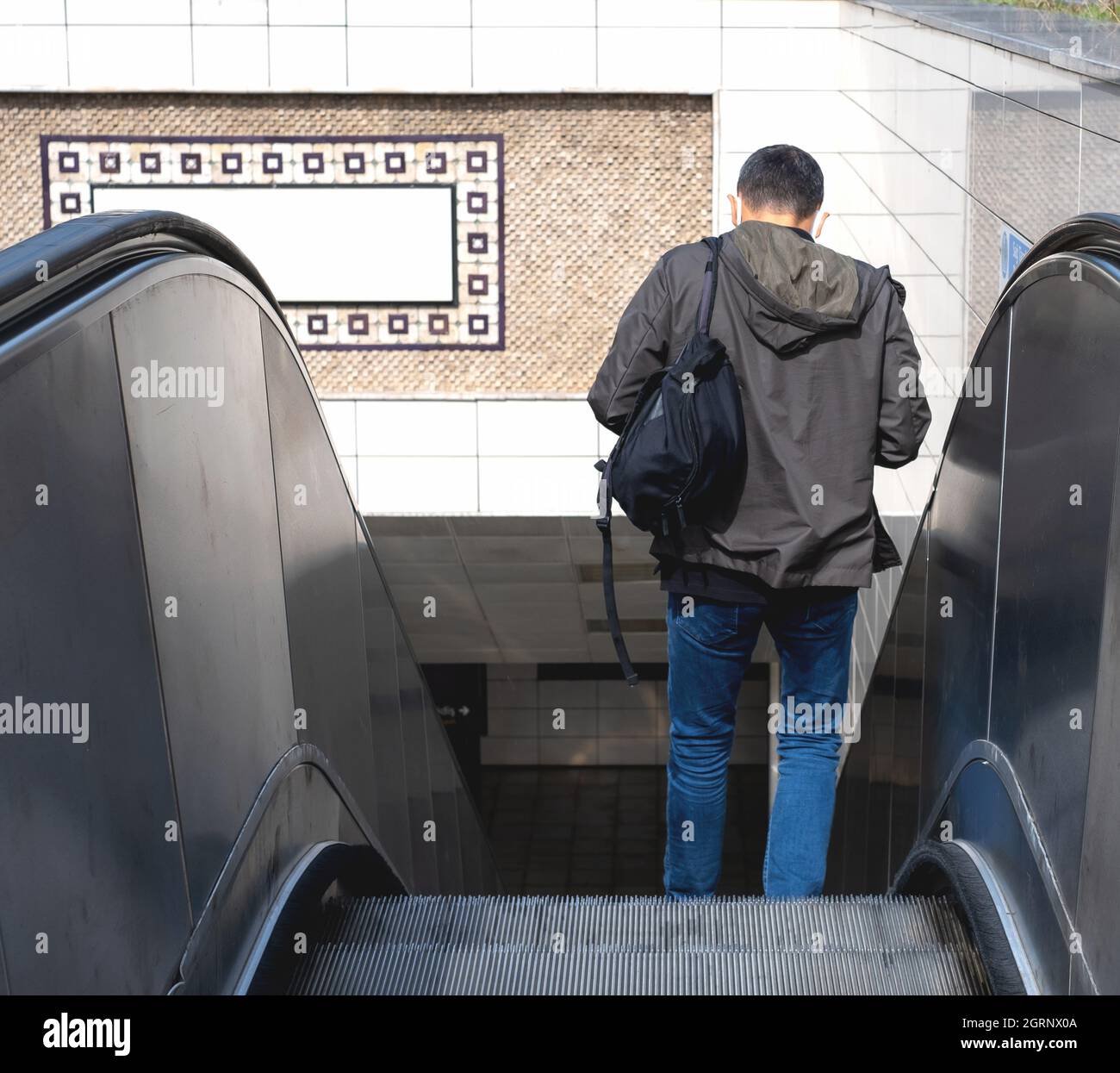 Homme descendant l'escalier roulant.Homme descendant de l'escalier roulant au métro avec son dos tourné. Banque D'Images