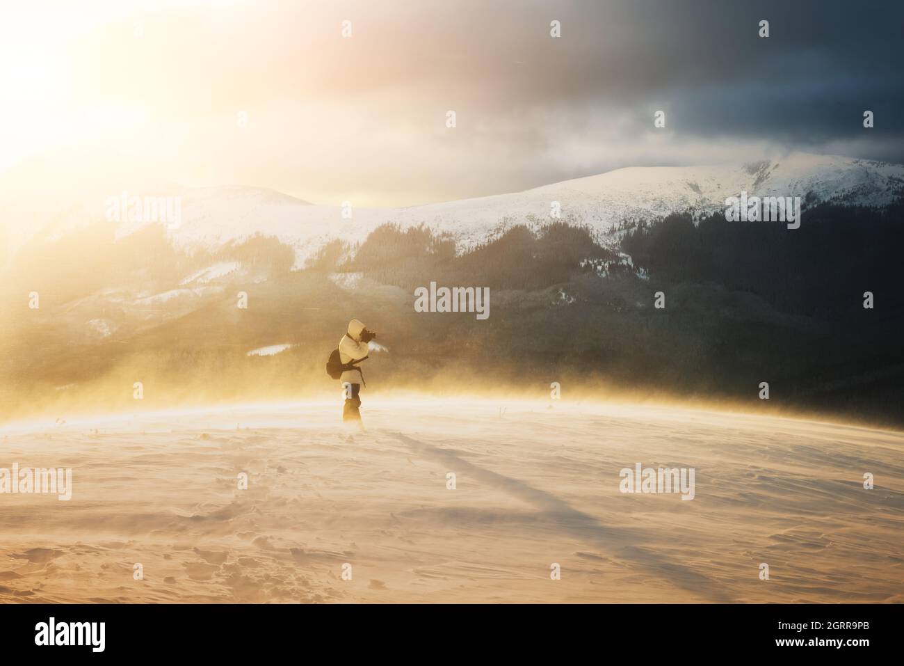 Photographe seul en montagne en pleine tempête avec un sac à dos en hiver. Concept de voyage. Les montagnes des Carpates. Photographie de paysage Banque D'Images
