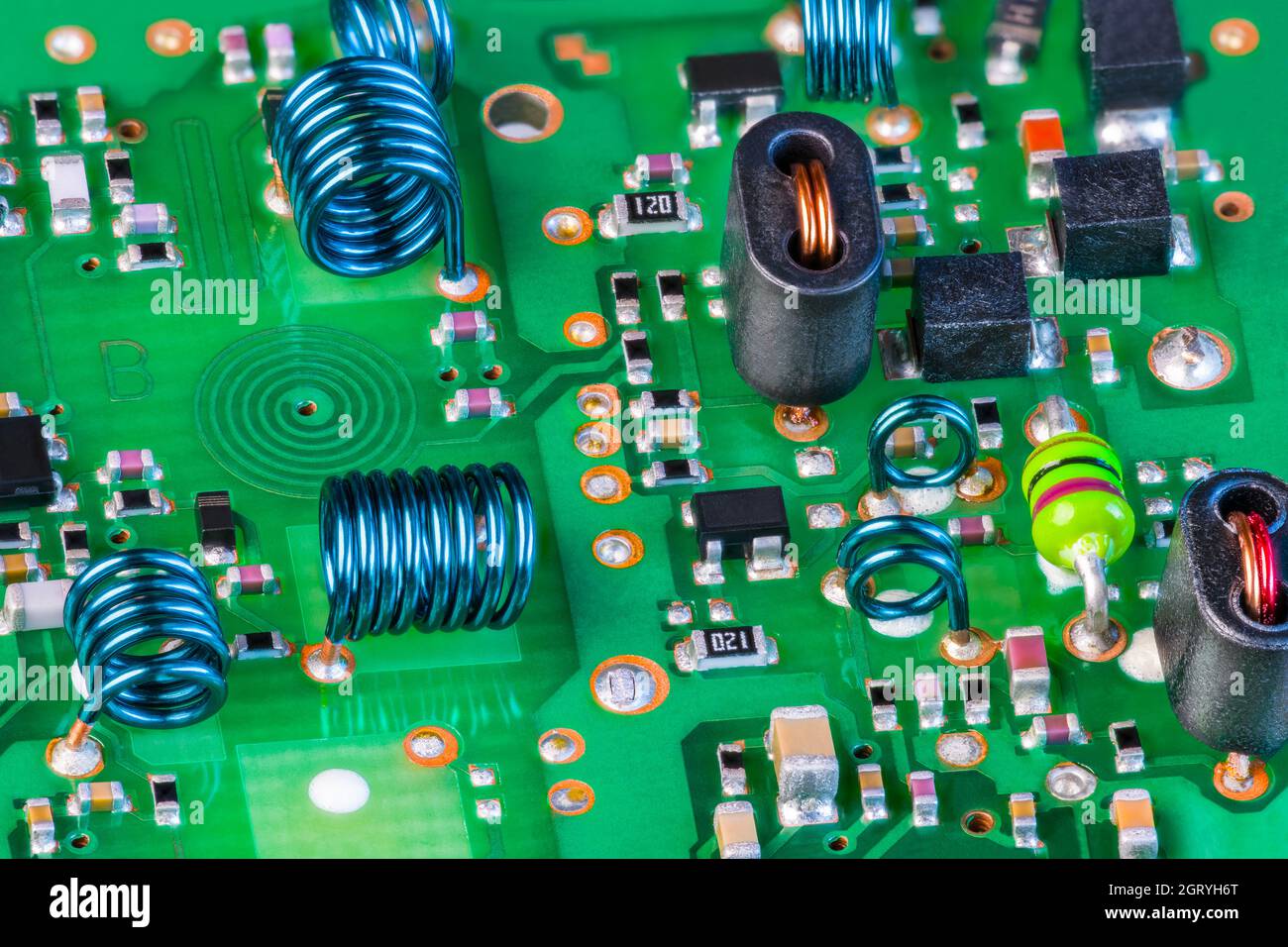Composants électroniques à la réception du signal de radiofréquence, circuit imprimé vert. Bobine en spirale plane dans la couche de ci, inductances à noyau d'air dans la carte TV. Banque D'Images