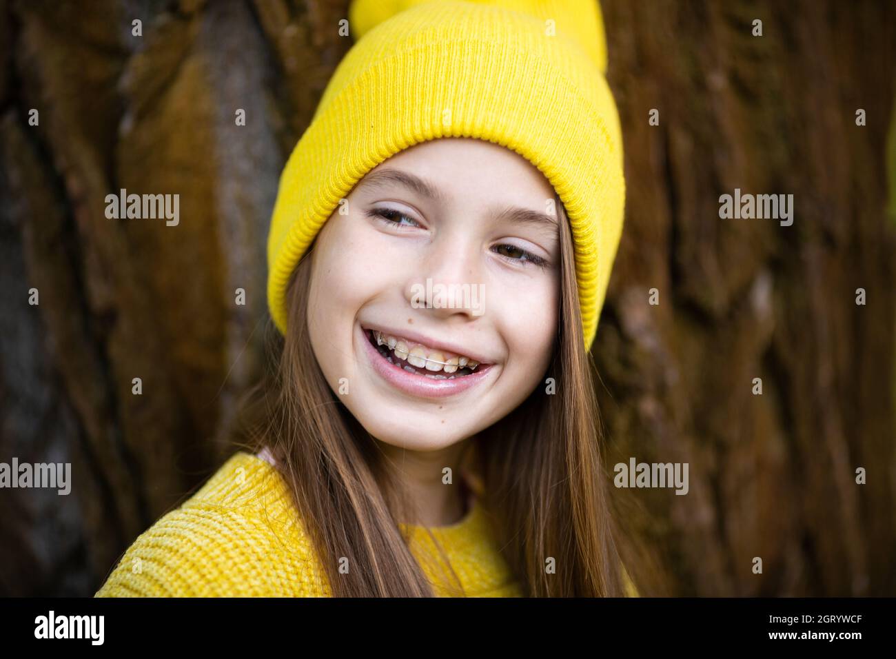 Jolie fille adolescente portant des bretelles souriantes vêtues de  vêtements jaune vif à l'extérieur. Adorable et heureuse jeune fille avec  des bretelles souriant à la camisole Photo Stock - Alamy