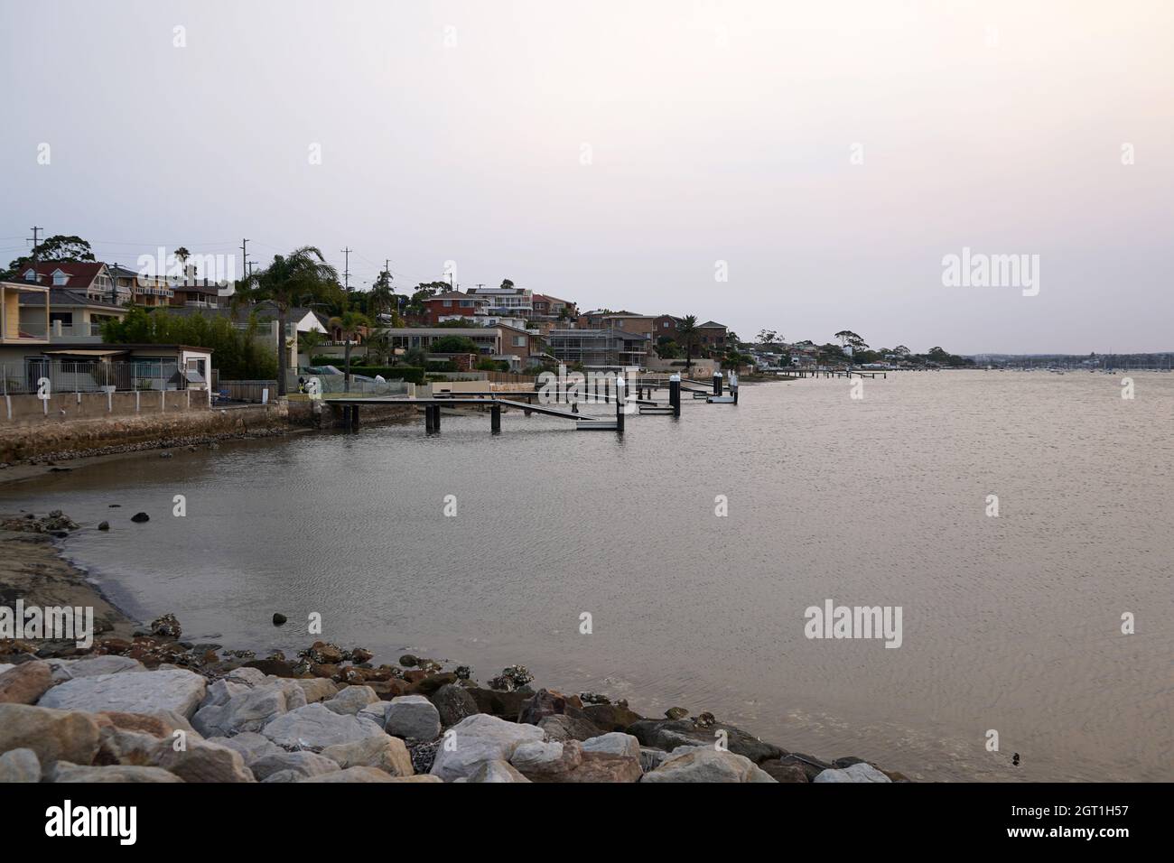 Maisons en bord de mer avec jetées à sans souci, une banlieue sud de Sydney. Banque D'Images