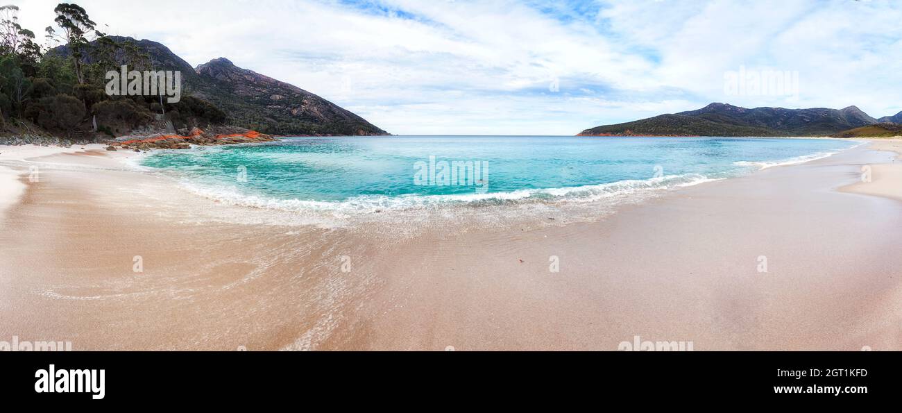 Panorama des sables blancs et des eaux cristallines sur la plage de la baie de Wineglass, sur la péninsule de Freycinet en Tasmanie, et sur un parc national reculé. Banque D'Images