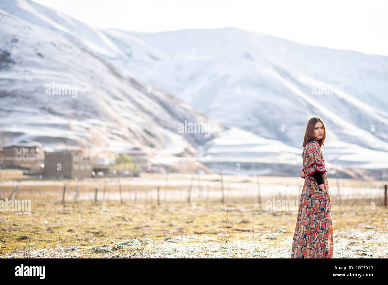 Vue latérale Portrait d'une femme debout sur le terrain contre les montagnes enneigées Banque D'Images