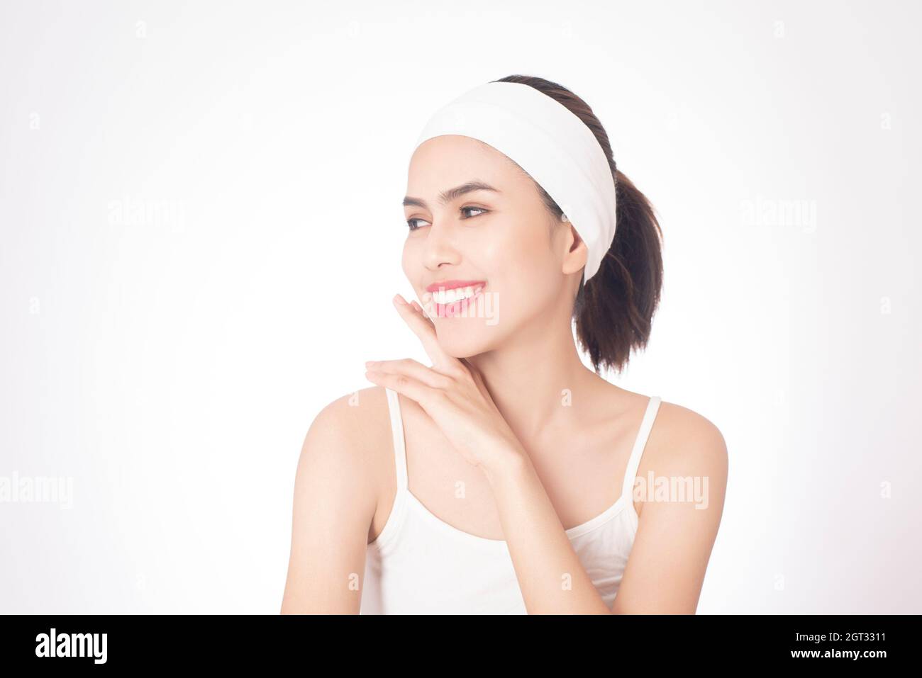 Jeune femme portant un serre-tête sur fond blanc Banque D'Images
