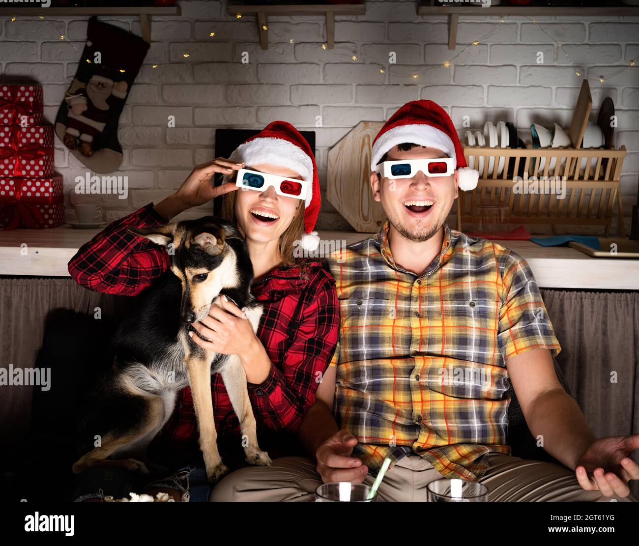 Soirée cinéma.Jeune couple en lunettes 3d regardant des films à la maison à  Noël pointant vers l'écran Photo Stock - Alamy