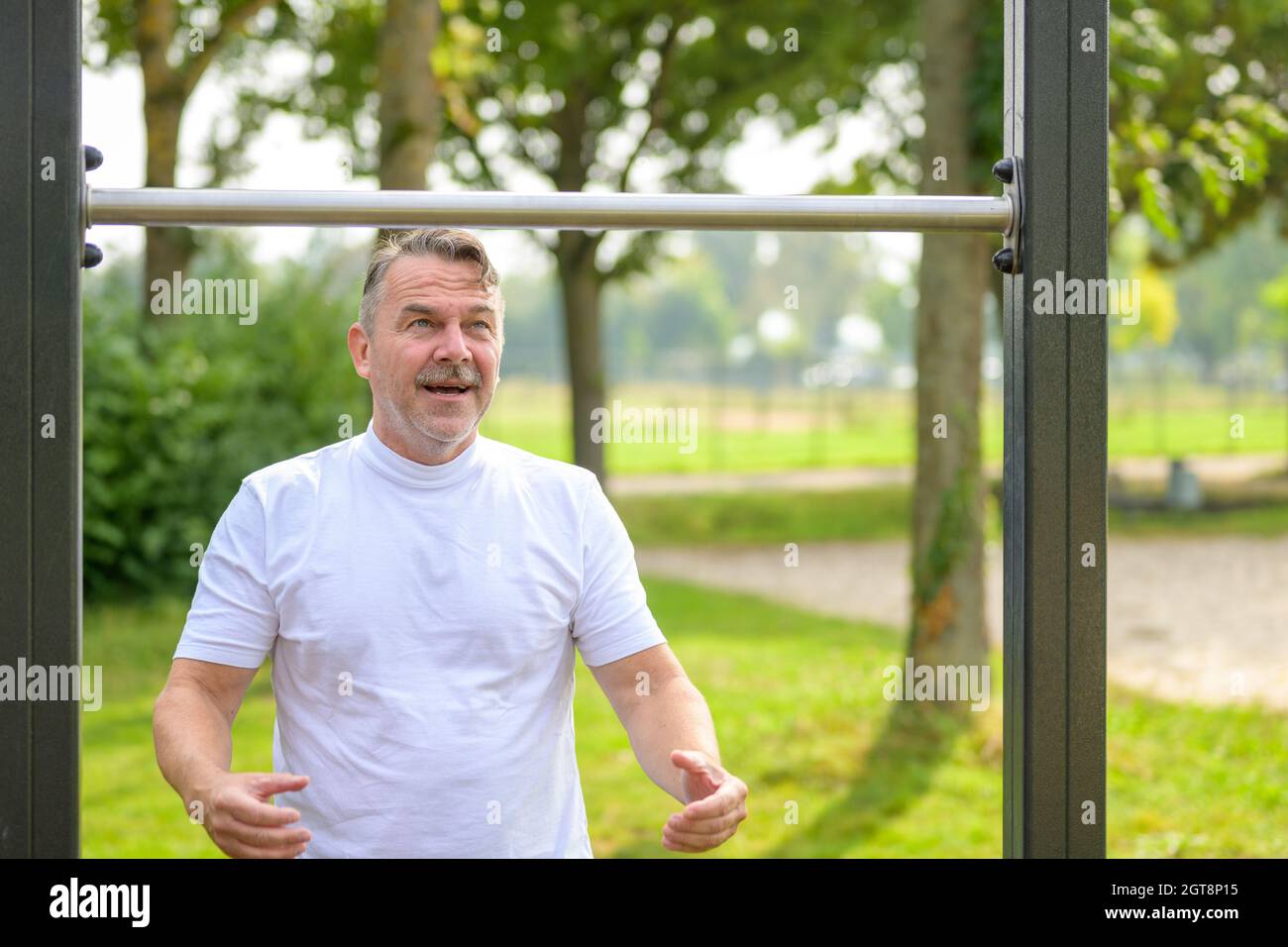 Un homme de haut niveau s'est mis à la recherche lors d'un entraînement en plein air sur des barres d'exercice dans un parc prêt à prendre le contrôle d'une concentration déterminée Banque D'Images