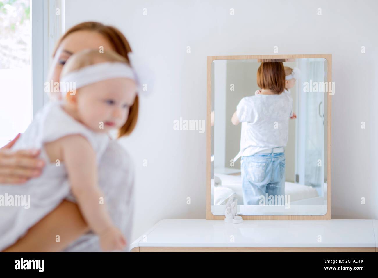 Reflet De La Vue Arriere D Une Jeune Mere Tenant Son Bebe Tout En Se Tenant Devant Le Miroir Dans La Chambre Tourne A La Maison Photo Stock Alamy