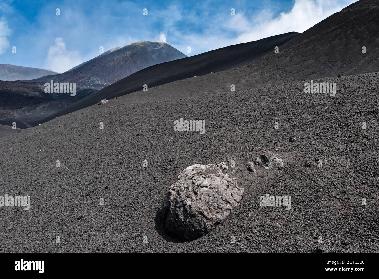 Vue sur le cratère volcanique du sud-est de l'Etna, Sicile, Italie.Au premier plan se trouve une énorme « bombe de lave » récemment éjectée du cratère Banque D'Images