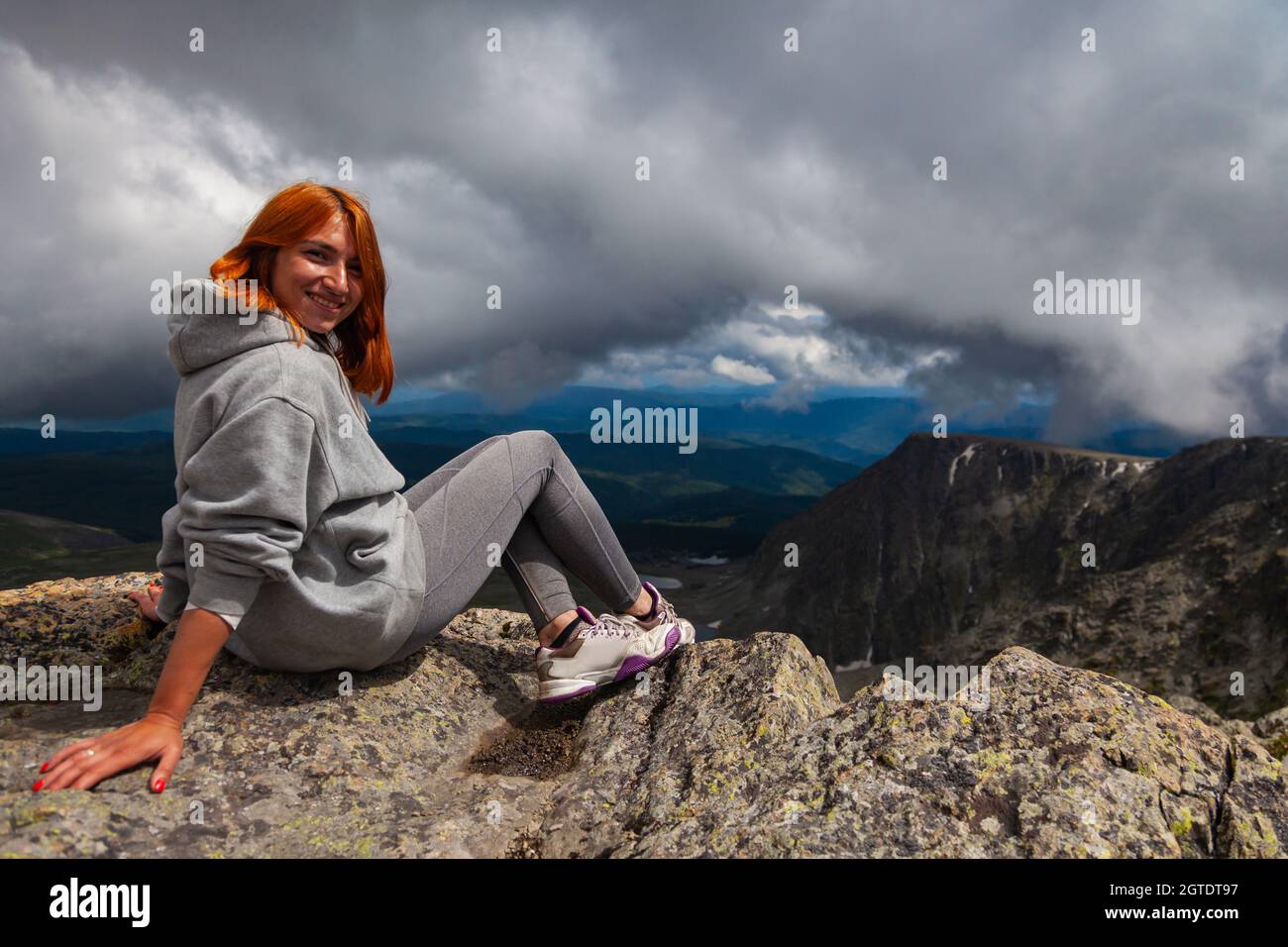Jeune femme touristique se détendant et assis sur le dessus du montage et regardant Un paysage. Banque D'Images