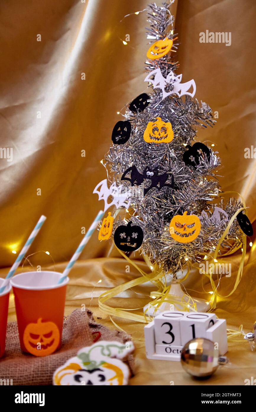 Arbre d'Halloween créatif avec citrouilles festives dans une atmosphère festive. Fêtes d'Halloween avec mug à motif citrouille festif, petits gâteaux faits maison, décoration de fête Banque D'Images