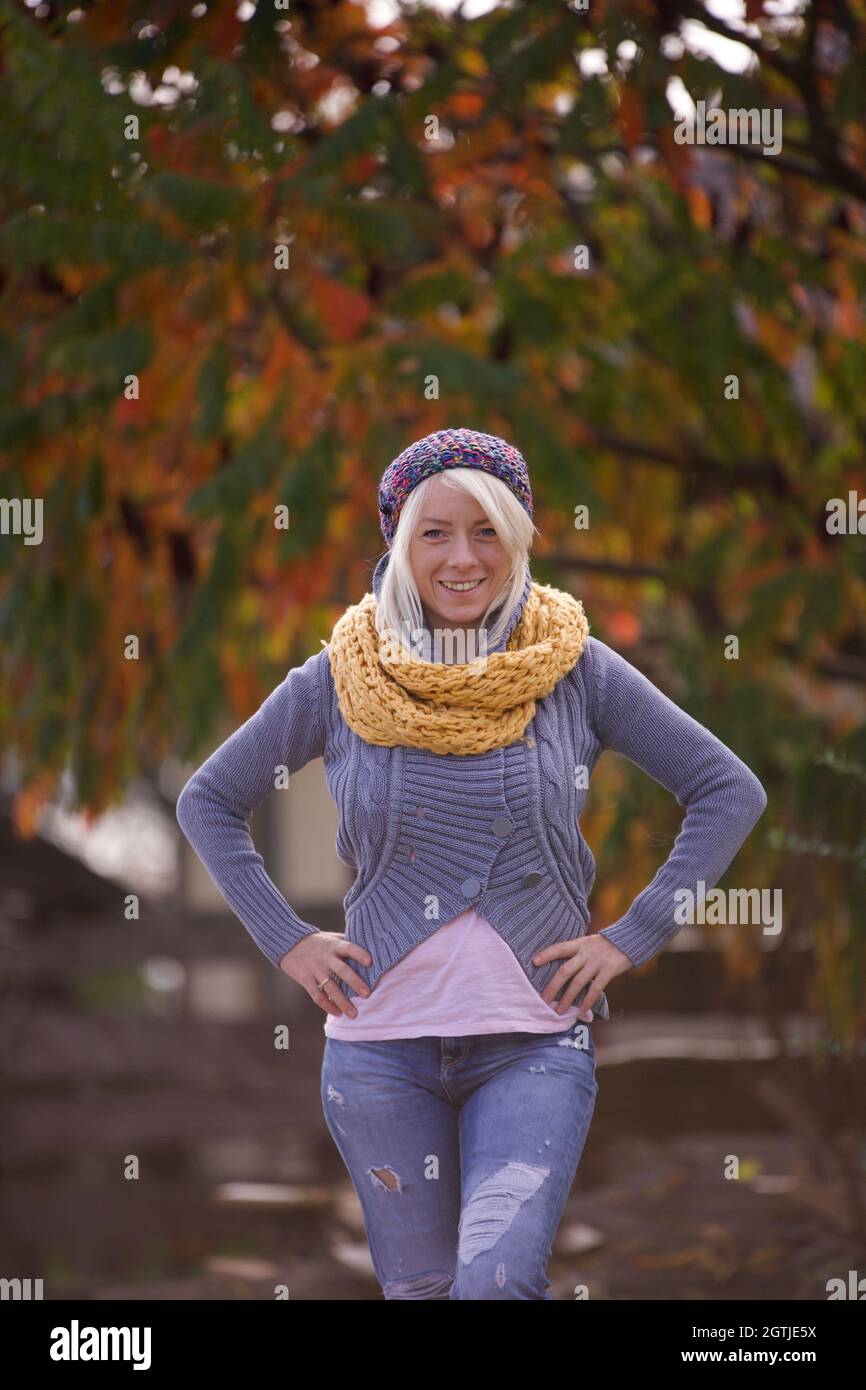 Blonde femme souriante vêtue de laine chandail beret écharpe en laine à  l'extérieur en automne.Couleurs Photo Stock - Alamy
