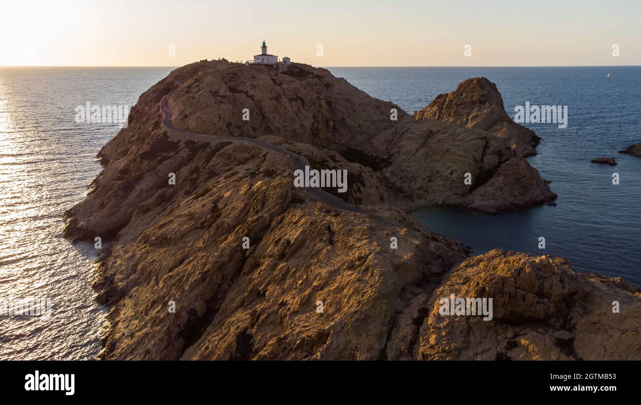 Vue aérienne du phare de l'île de Pietra avec un ferry jaune amarré dans le port de l'Île Rousse en arrière-plan, haute-Corse, France - photo Banque D'Images