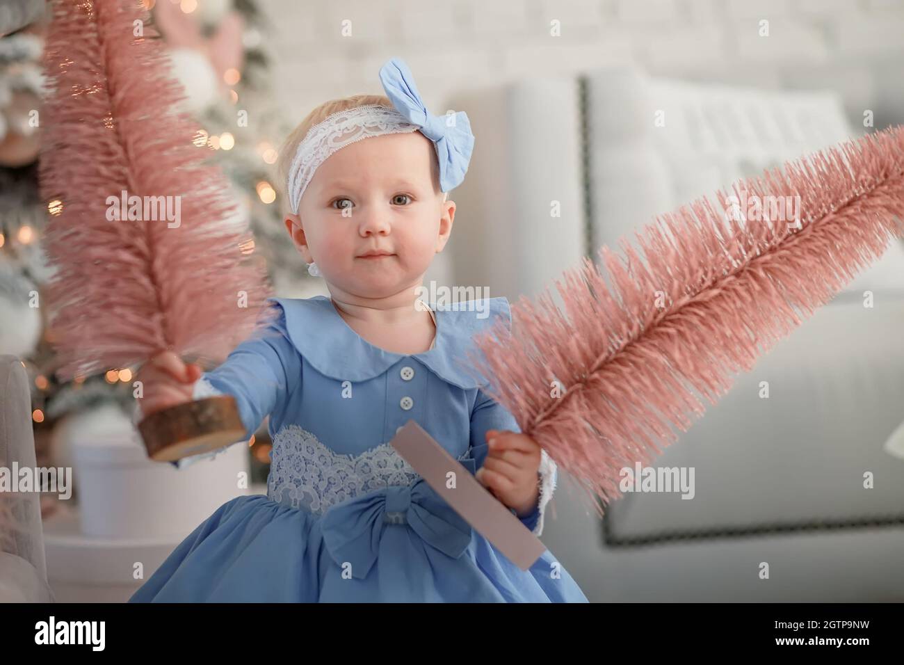 Belle fille tenant arbre de Noël. Bébé heureux fête Noël et le nouvel an Banque D'Images