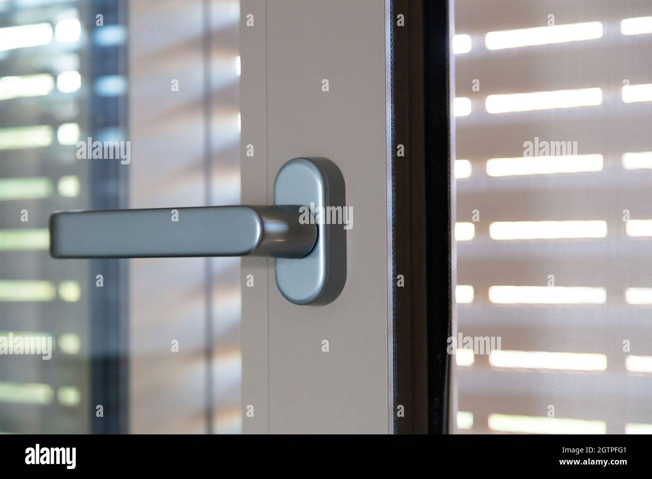 Ouvrir le cadre de porte vitrée en acier ou en plastique et les stores, vue rapprochée de la poignée. Détail fenêtre en aluminium ou PVC. Banque D'Images