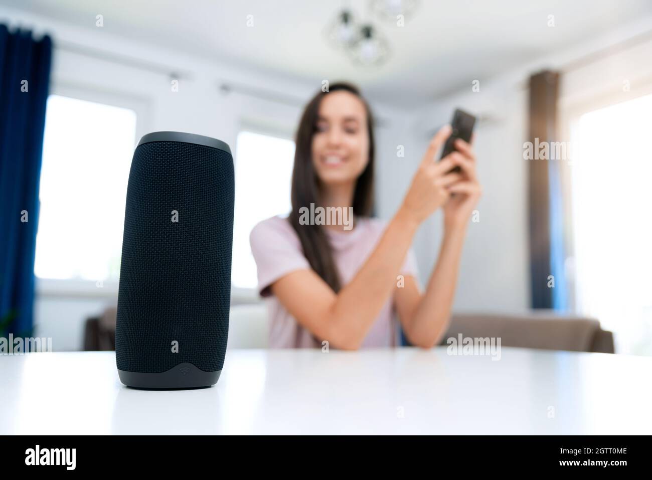 Femme utilisant une enceinte intelligente, un système domestique intelligent, un assistant moderne Banque D'Images