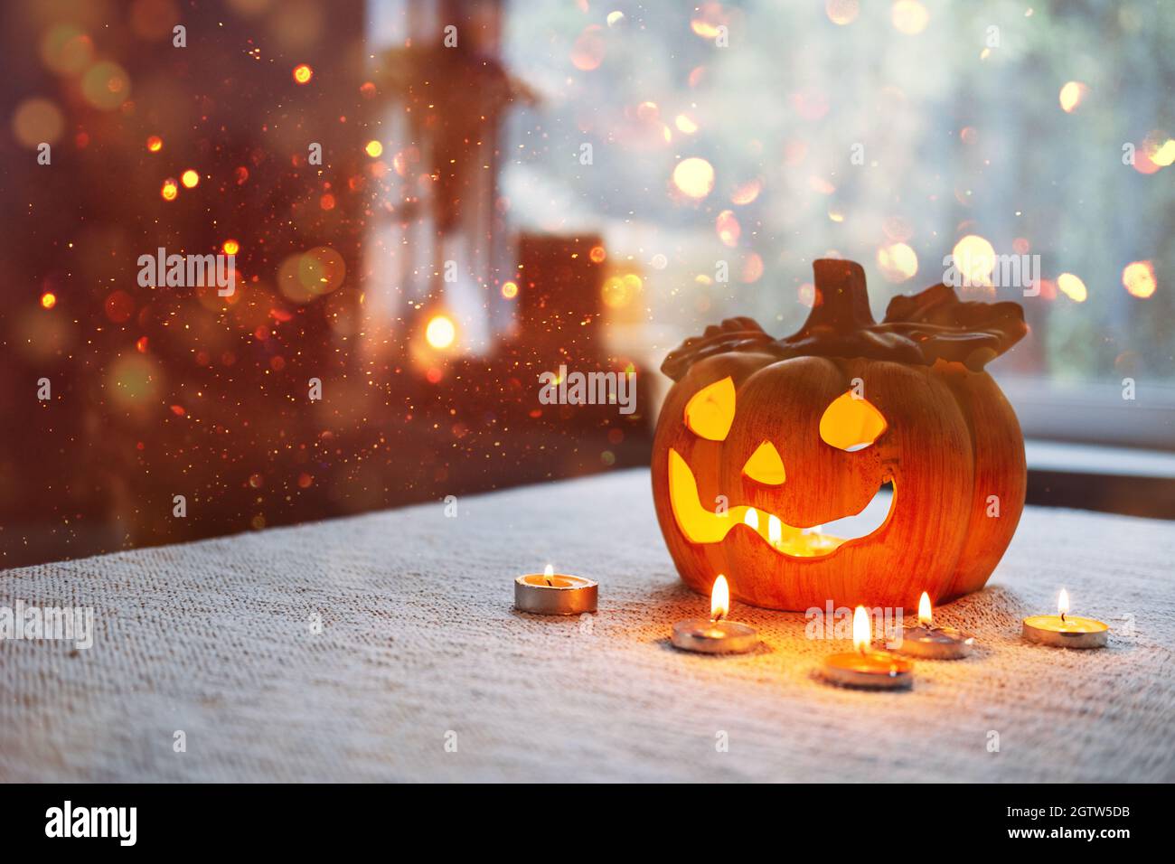 Lampe de citrouille d'Halloween avec bougies dans la table à la maison. Symbole d'Halloween, décorations d'intérieur. Lanterne de citrouille d'Halloween avec bokeh Banque D'Images