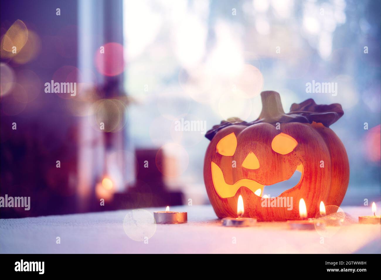 Lampe de citrouille d'Halloween avec bougies dans la table à la maison. Symbole d'Halloween, décorations d'intérieur. Lanterne de citrouille d'Halloween avec bokeh Banque D'Images
