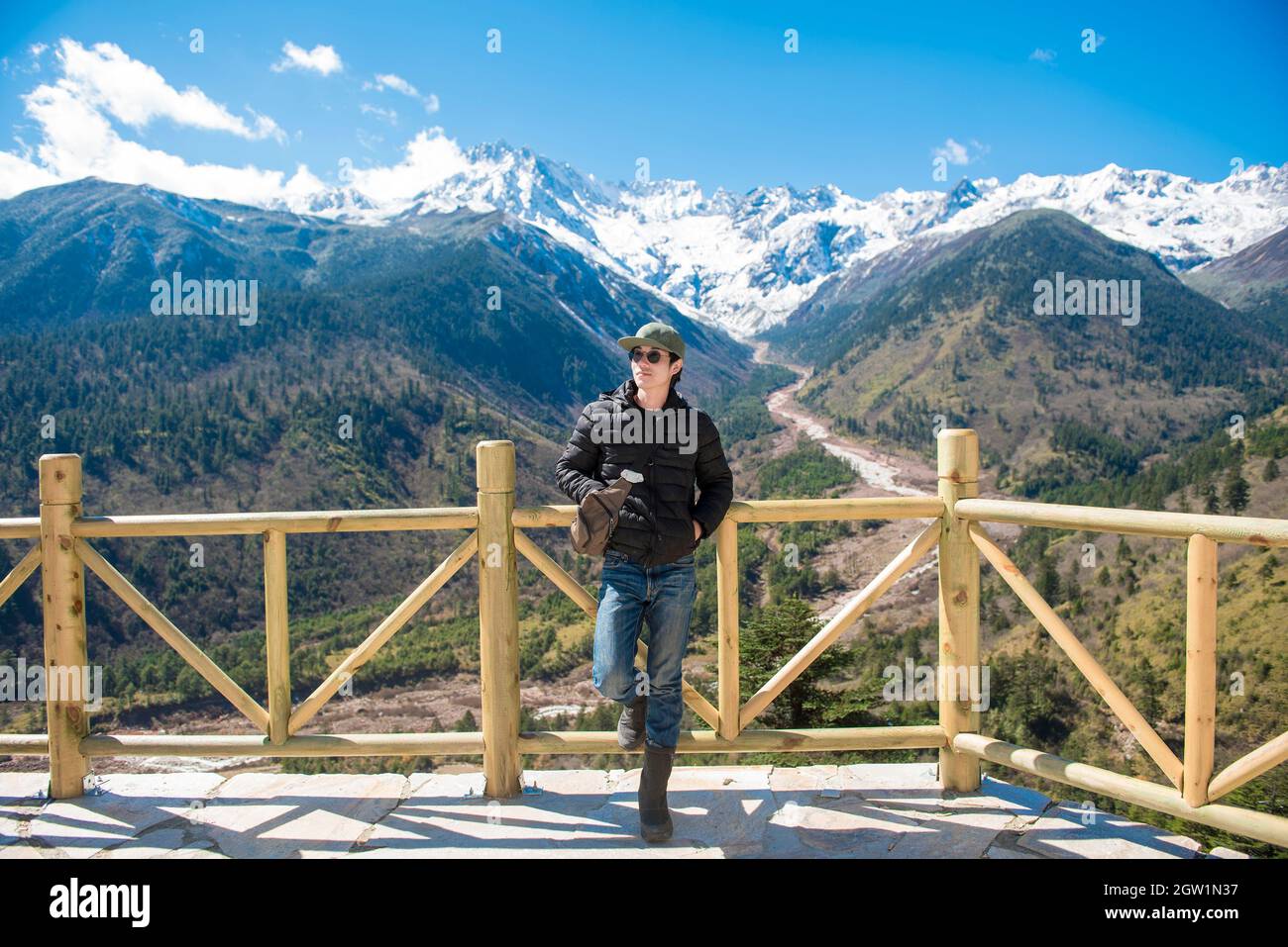 Beau homme debout au point d'observation contre les montagnes en hiver Banque D'Images